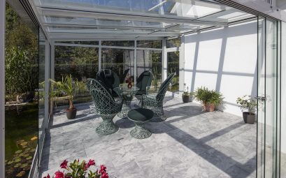 Véranda en aluminium et en verre aménagée en jardin d'hiver